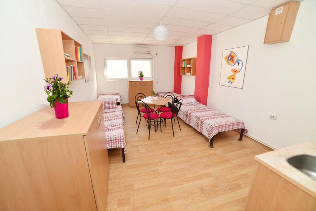 a room with a kitchen and a table and chairs at HILJADNIKOV Apartments in Štip