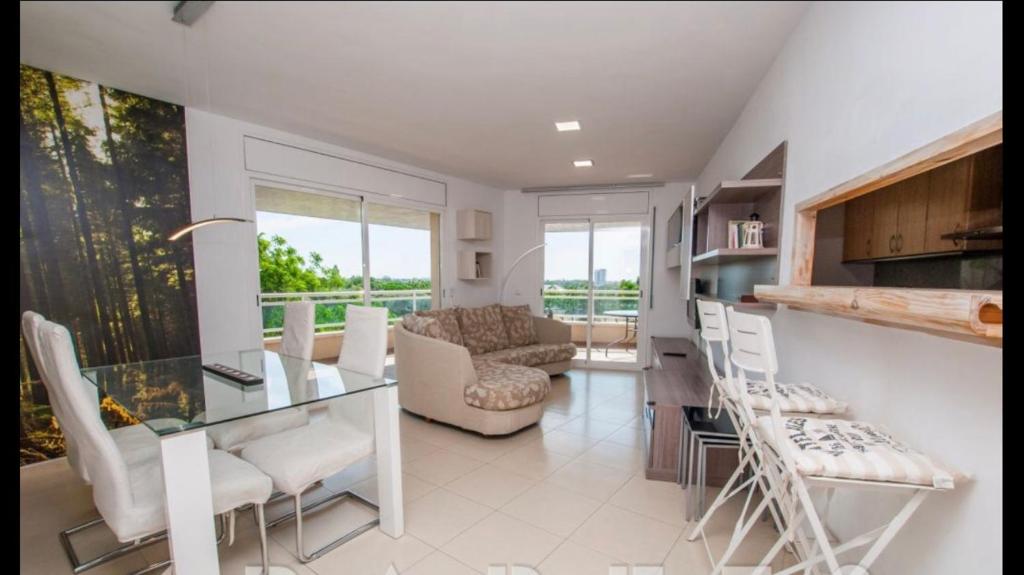 a kitchen and living room with a glass table and chairs at Apartaments Cambrils Suite Costa Daurada in Cambrils