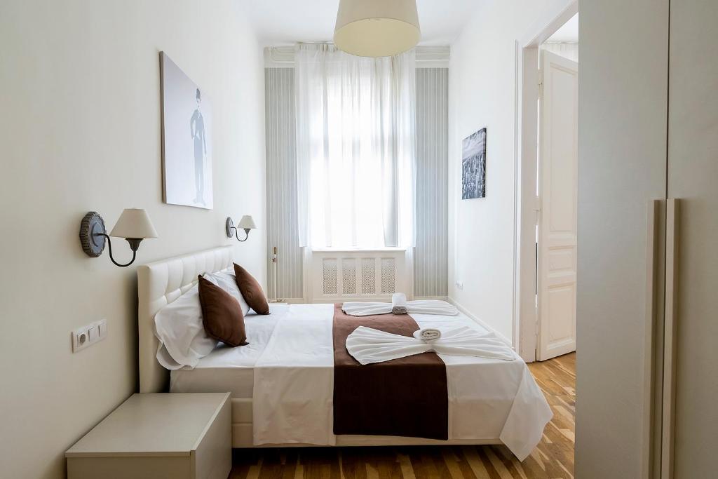 a bedroom with a white bed and white walls at Luxury & Panorama Apartments in Budapest