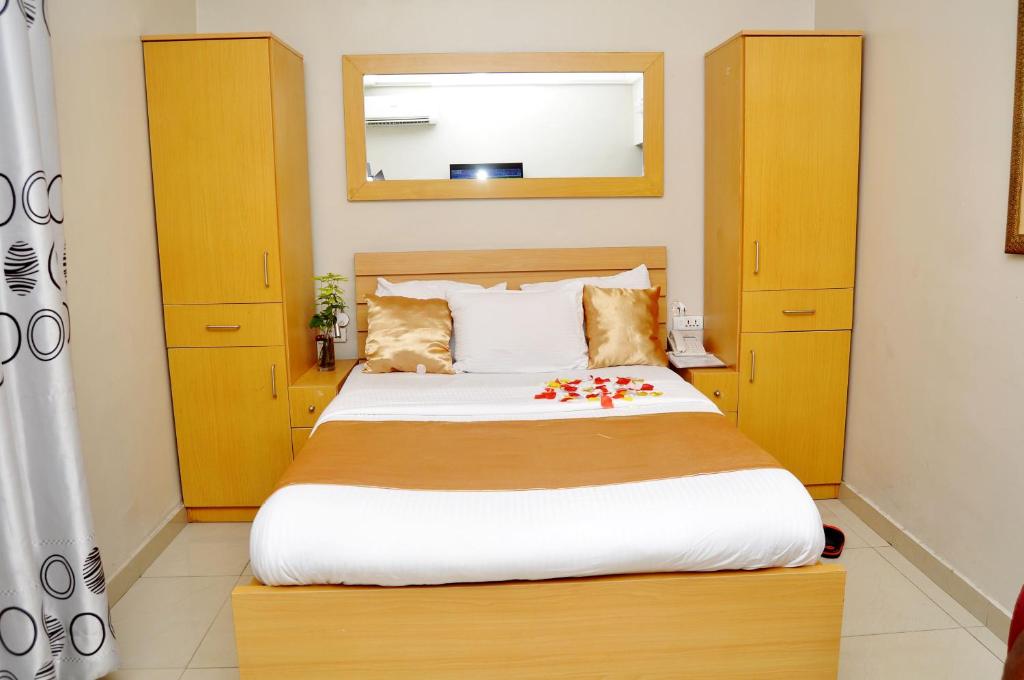 a bedroom with a large bed with yellow cabinets at Primal Hotel in Ikeja