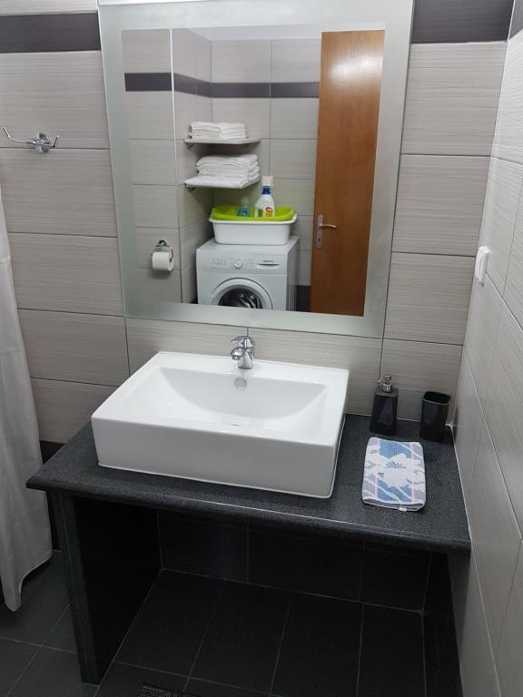 łazienka z umywalką i pralką w obiekcie Bourlis Apartments w mieście Asprovalta