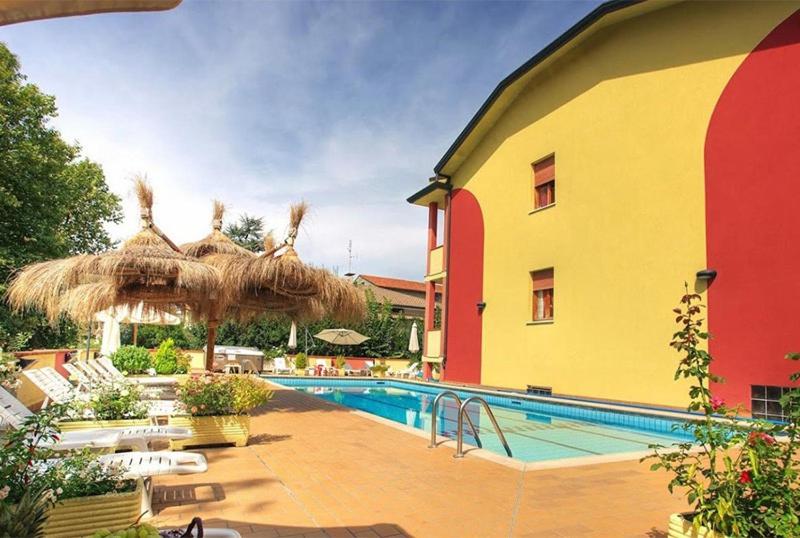 un hôtel avec une piscine et un bâtiment dans l'établissement Hotel Residence Elisabetta, à Cesenatico