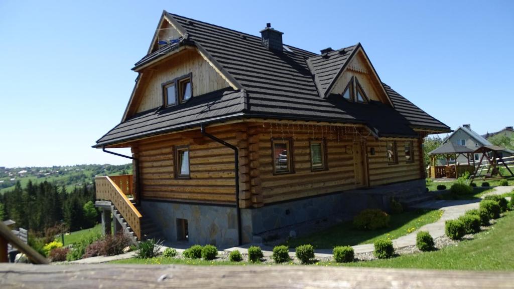 una casa de madera con techo abuhardillado en Chata Istebna, en Istebna
