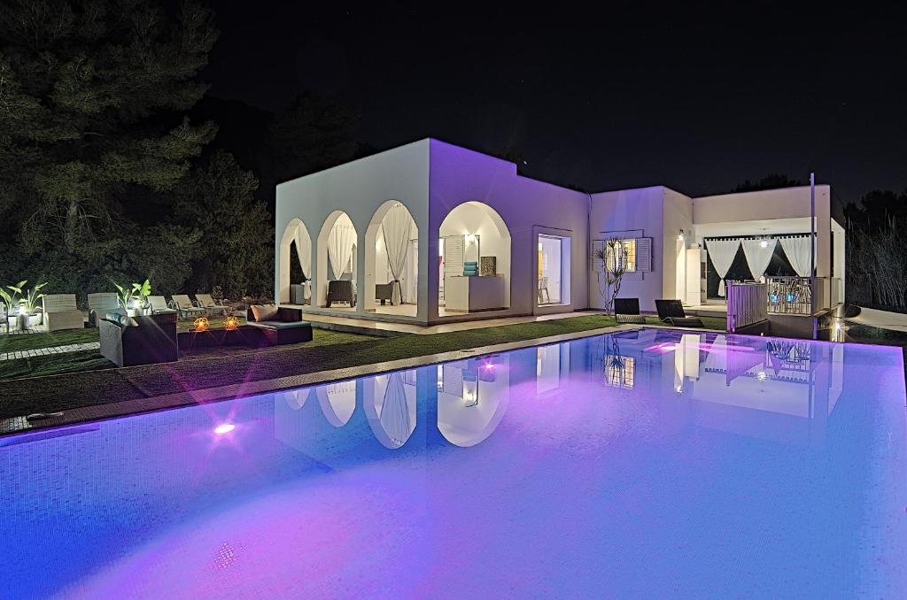 basen w nocy z fioletowymi światłami w obiekcie Can Garchet White Ibiza w mieście Sant Jordi