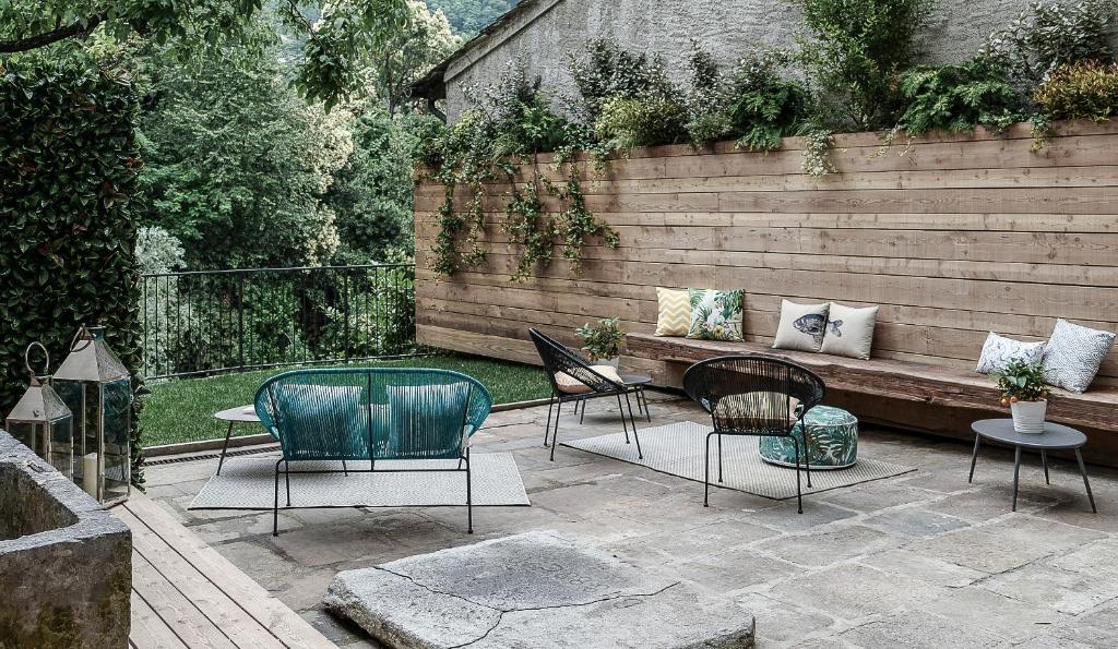 a patio with chairs and a bench in a backyard at Palazzo Giani in Chiavenna