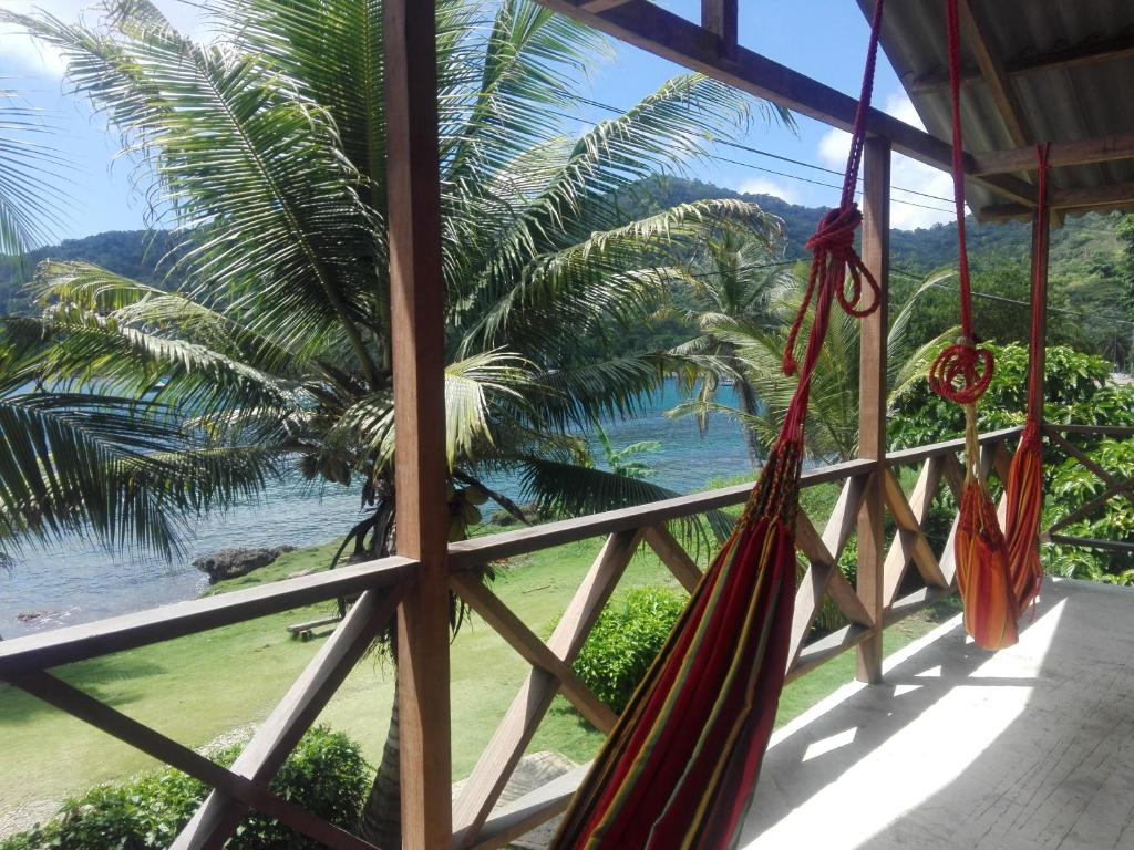 a view of the ocean from a porch with hammocks at Hostal El Chileno Sapzurro in Sapzurro
