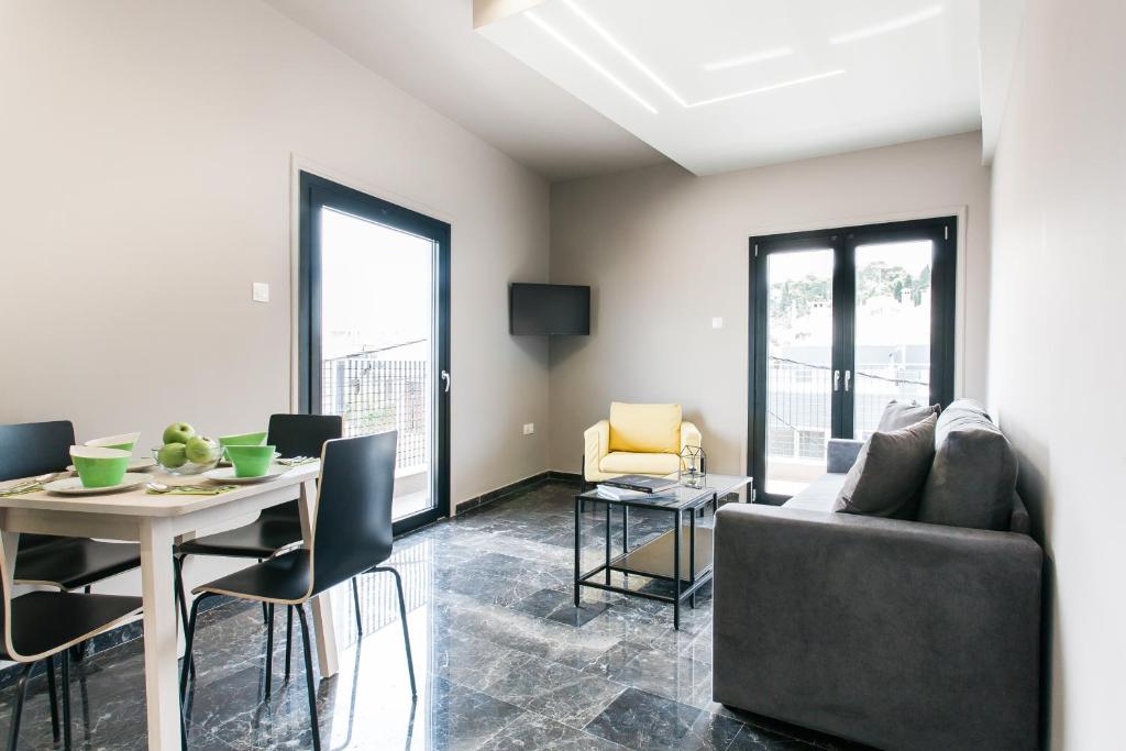 uma sala de estar com uma mesa e um sofá em Greece U Around Athens Thissio Suites em Atenas