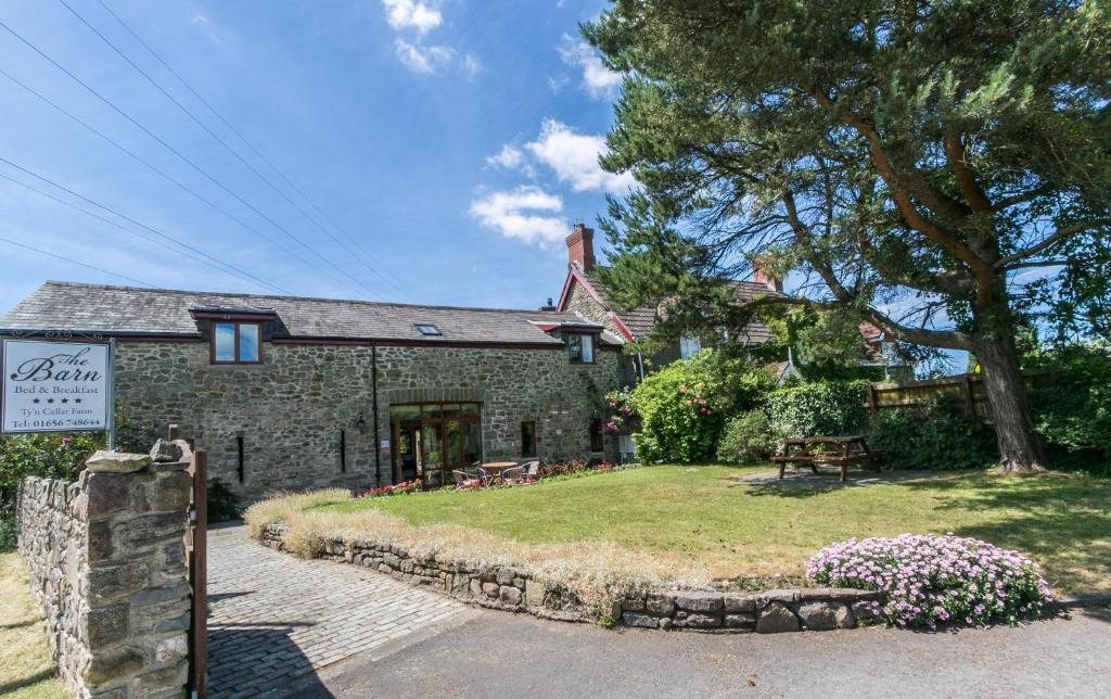a stone building with a sign in front of it at The Barn B&B in Margam