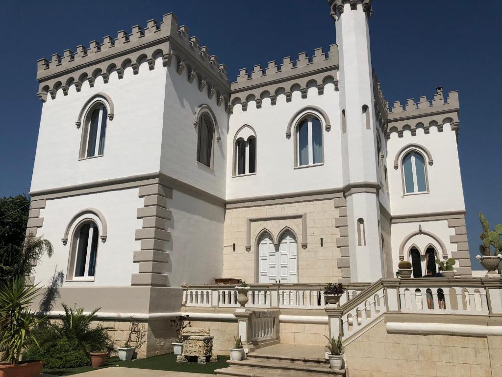 Un bâtiment blanc avec une tour en haut dans l'établissement Torre Balzano B&B, à Valenzano