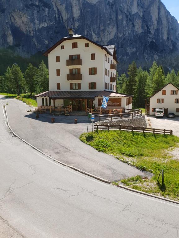 un grande edificio sul lato di una strada di Hotel Al Sasso Di Stria - 13 Maggio a Livinallongo del Col di Lana