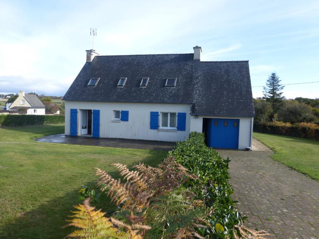 a white house with blue doors and a yard at les volets bleus in Camaret-sur-Mer