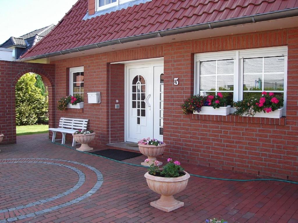 Langen的住宿－Bremerhaven-Langen，砖房,前面有两盆花