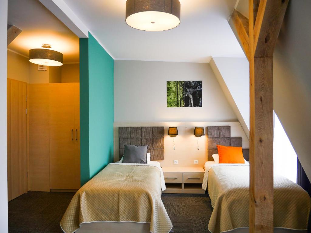 2 łóżka w pokoju z niebieskimi i zielonymi ścianami w obiekcie Aparthotel CENTRUM Gliwicka 18 w Bytomiu