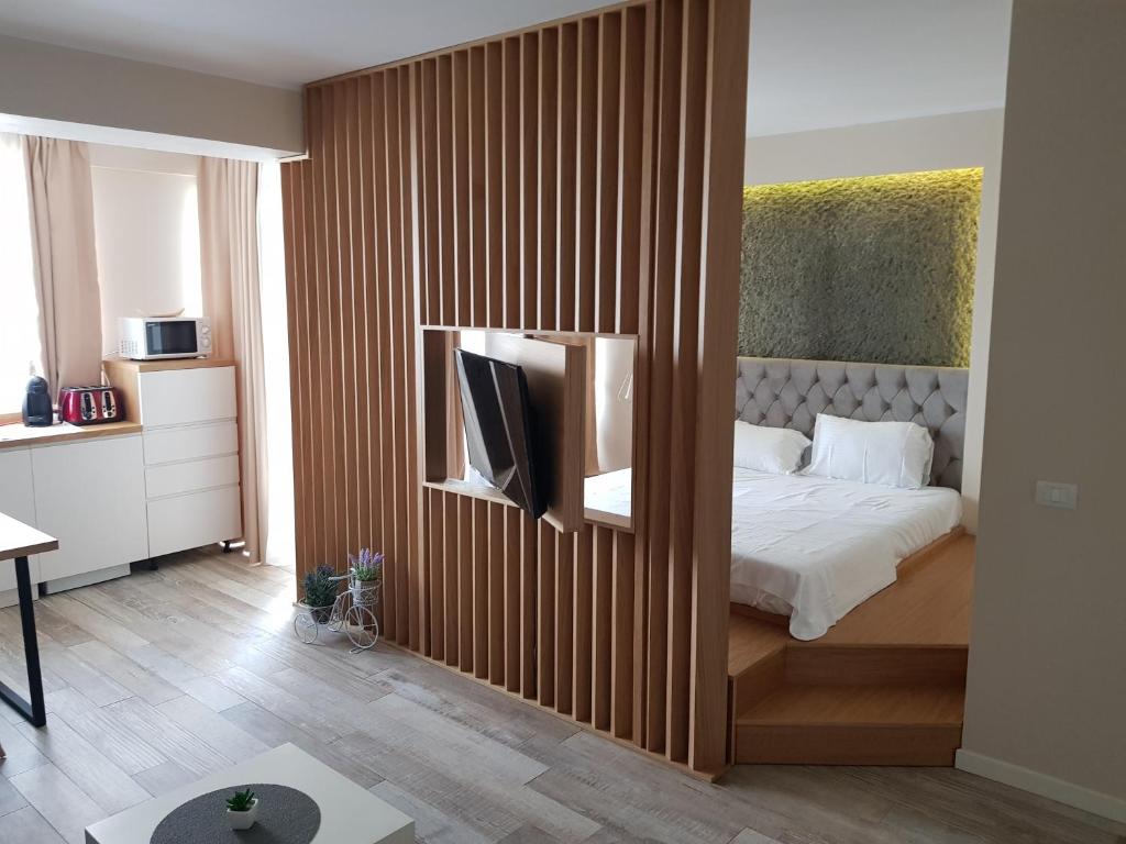 um quarto com uma cama e uma televisão na parede em Miramar Residence em Mamaia