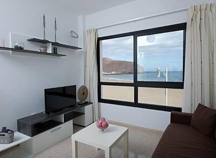 - un salon avec une grande fenêtre donnant sur l'océan dans l'établissement Apartamentos Candelarita, à Gran Tarajal