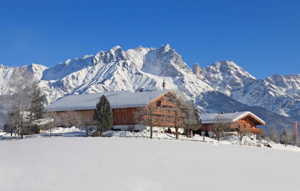 a log cabin in front of a snow covered mountain at Vorderkasbichlhof in Saalfelden am Steinernen Meer