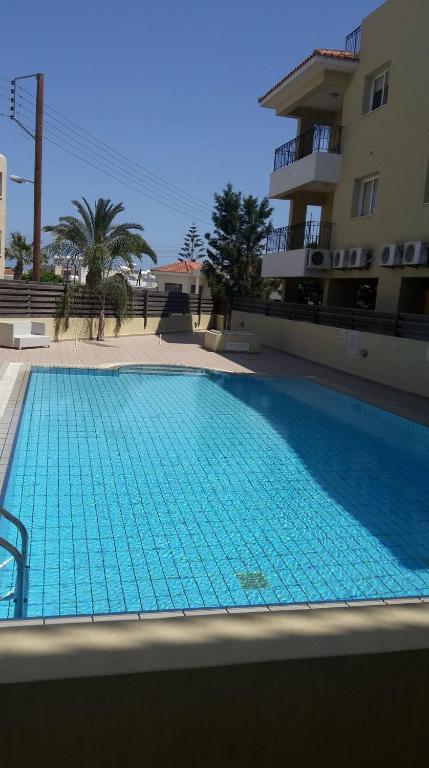 a large blue swimming pool next to a building at Hermes complex1 paralimni in Paralimni