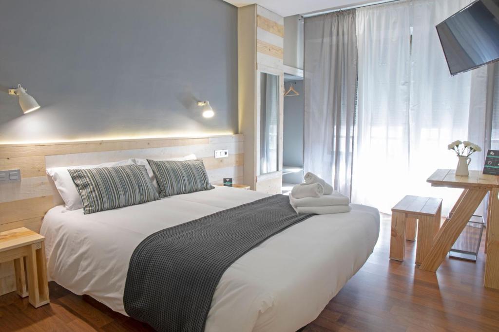 ein Schlafzimmer mit einem großen Bett und einem Fenster in der Unterkunft Hotel Alda Centro Ponferrada in Ponferrada