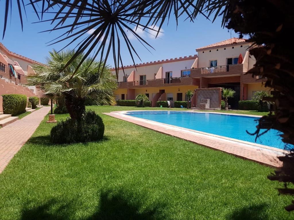 a courtyard with a swimming pool and a building at Duplex in El Jadida