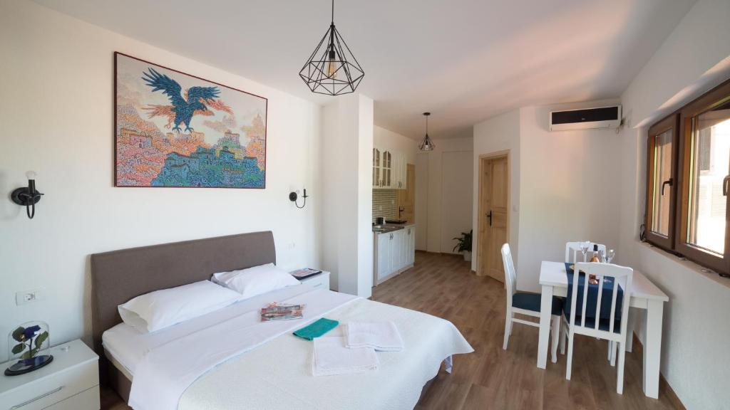a bedroom with a white bed and a table and chairs at Vasiliki in Virpazar