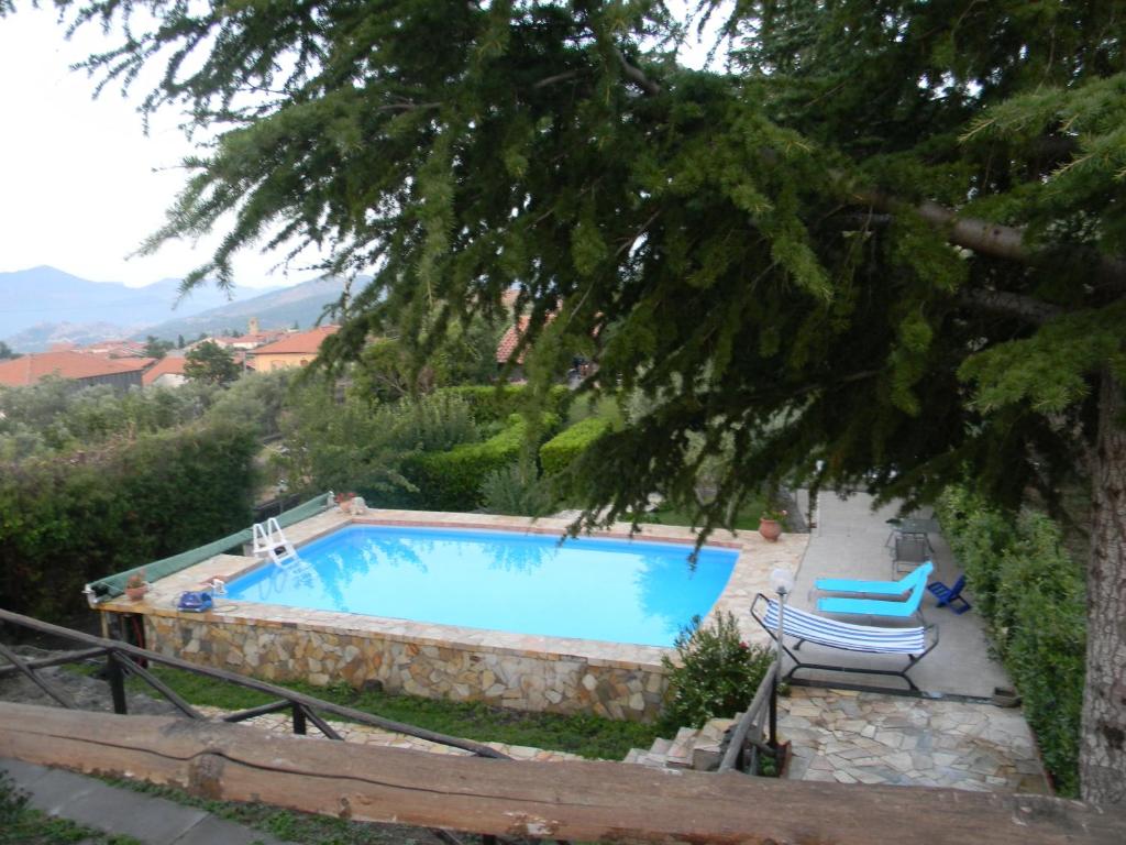 カスティリオーネ・ディ・シチーリアにあるLa Dolce Vita Country House with pool - Solicchiataのスイミングプール(椅子2脚、木付)
