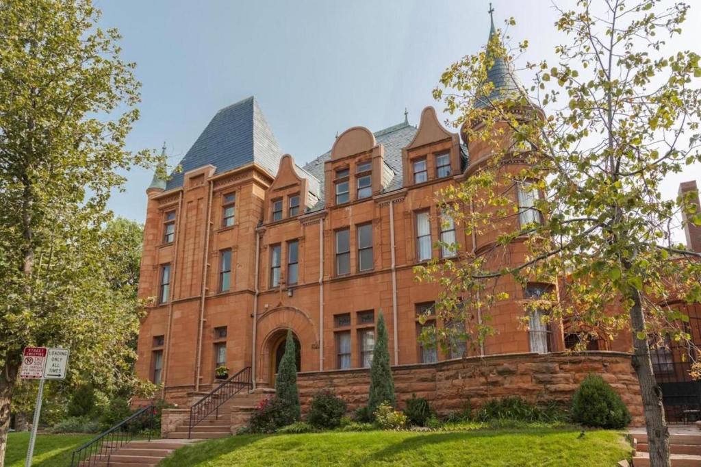 a large red brick building with stairs in front of it at Patterson Inn in Denver