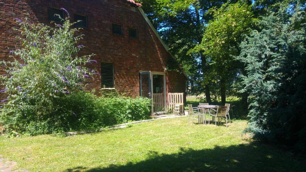 a brick house with a table and chairs in the yard at Rust en Stilte in de Natuur in Onstwedde