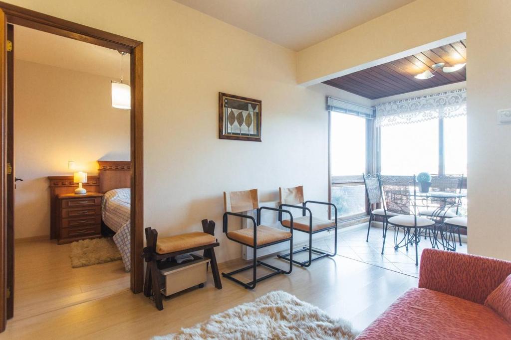 Habitación con cama, sillas y mesa. en Belo apartamento e completo no Centro com vista, en Gramado