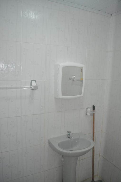 um banheiro branco com uma pia e um espelho em Sitio Os Tres em Camaçari
