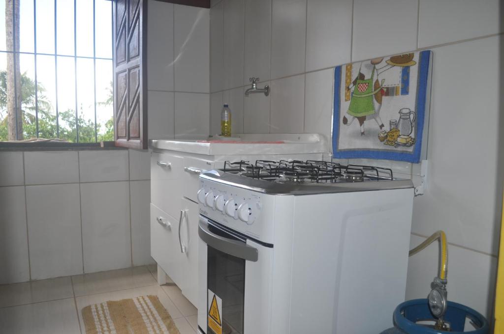uma cozinha branca com um forno com placa de fogão em Sitio Os Tres em Camaçari