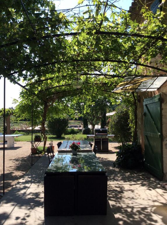 een patio met een tafel met bloemen erop bij La bergerie de Castellan in Verquières