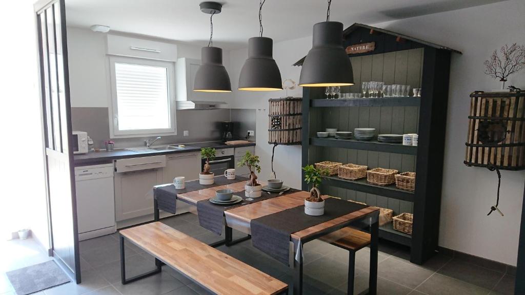 a kitchen with a table and chairs in a room at Nos Îles in Saint-Jean-de-Monts