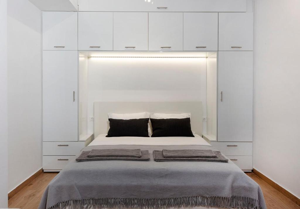 1 dormitorio con 1 cama grande y armarios blancos en Raise cosy apartment, en Atenas