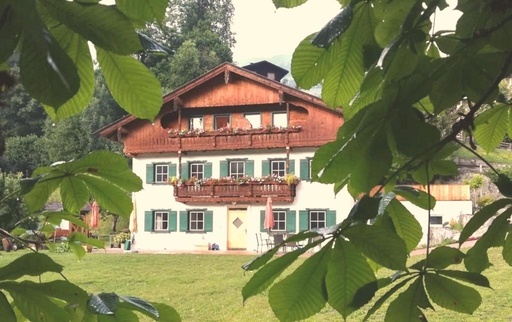 a large house with a balcony in a field at Appartementhaus Bad Salve in Hopfgarten im Brixental