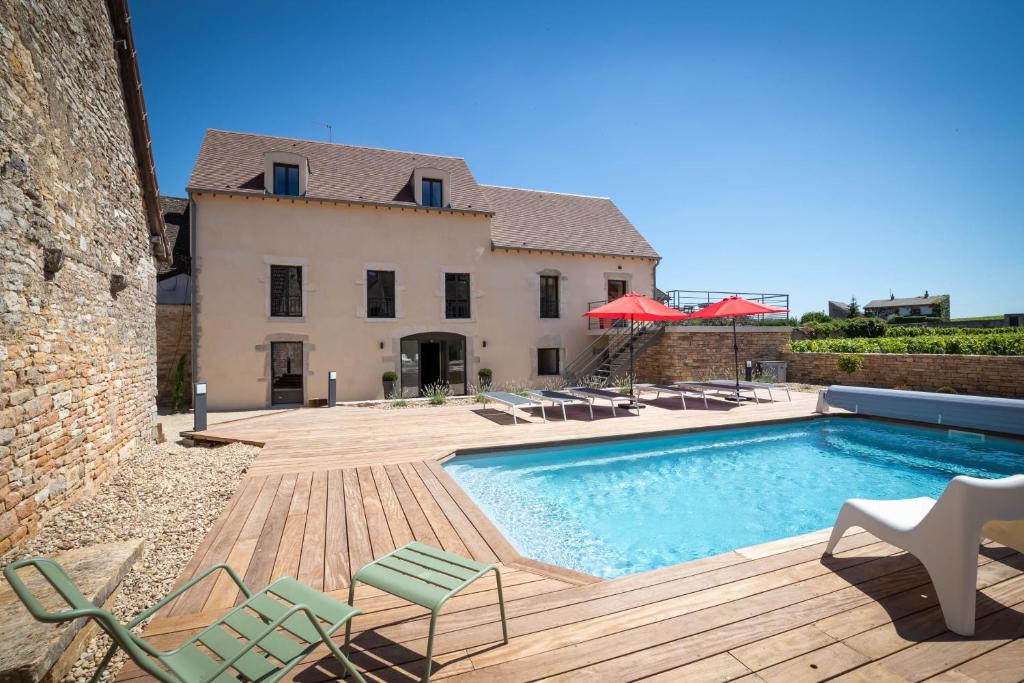 a villa with a swimming pool in front of a house at La Maison des Rugiens in Pommard