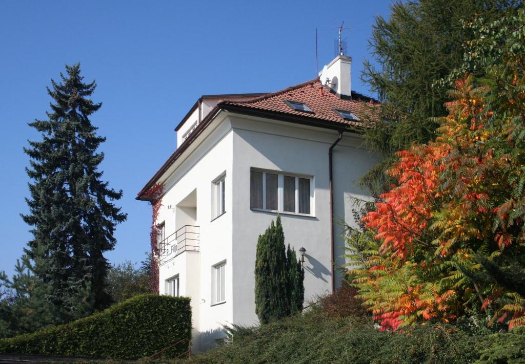 uma casa branca com um telhado vermelho numa colina em Pension Filip em Praga