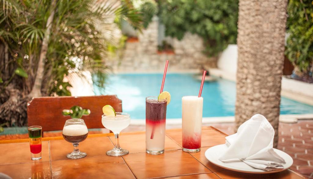 ein Holztisch mit vier Getränken darüber in der Unterkunft Hotel Carrillos Cancun in Cancún