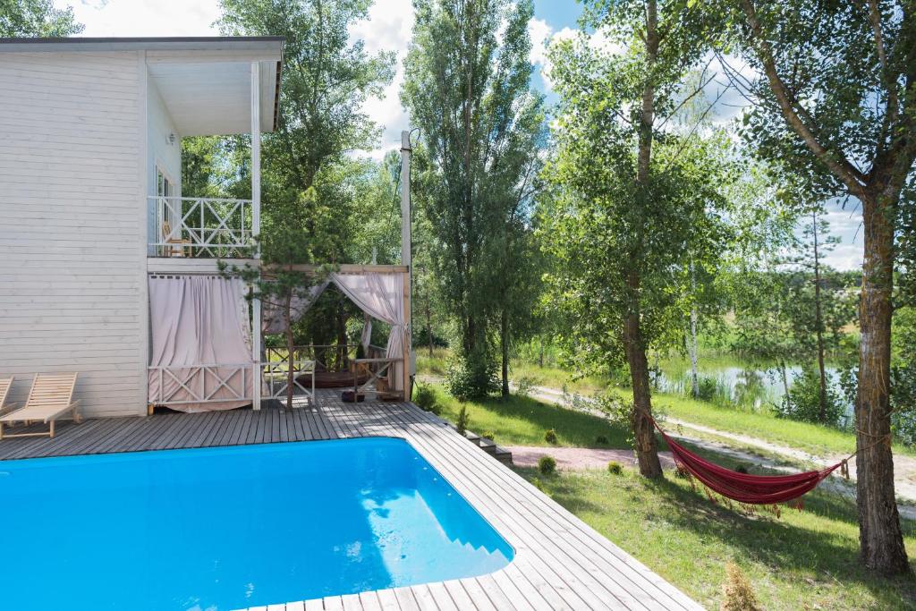 a pool with a hammock and a house at Relax villa Poduzska in Sinyak