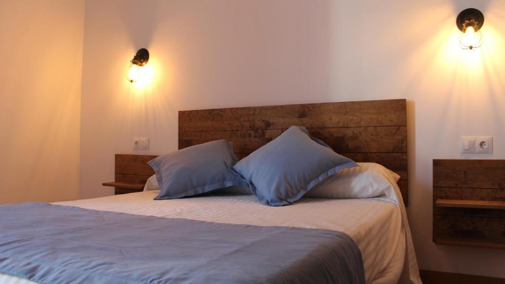 a bedroom with a bed with two blue pillows at Hospederia 1881 in Chiclana de la Frontera