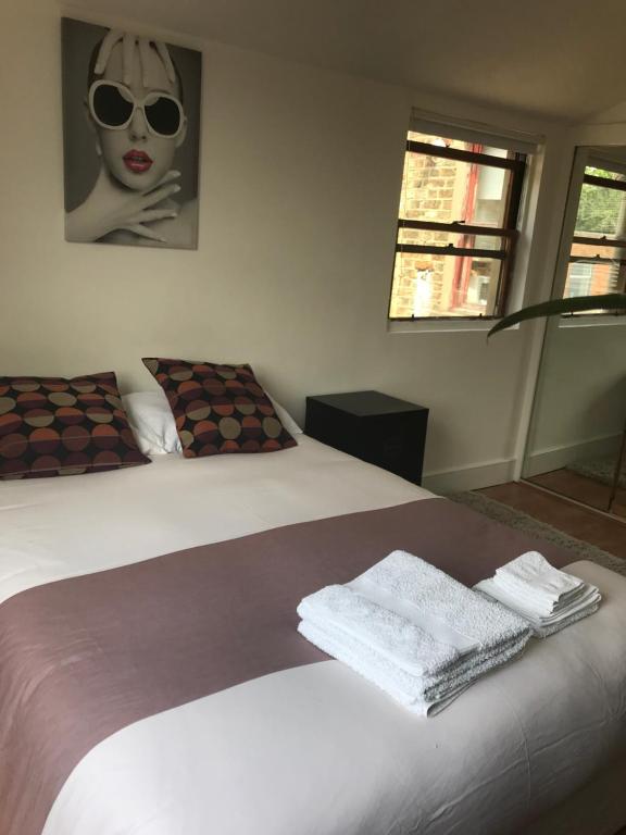 - une chambre avec un lit et des serviettes dans l'établissement Amazing Room, à Londres