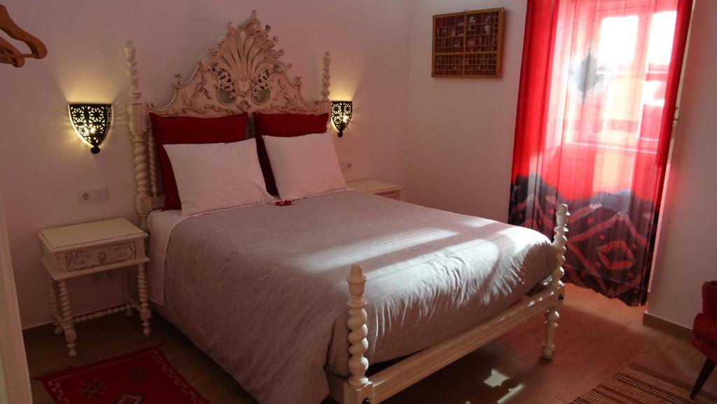 a bedroom with a bed with a red curtain at Casinhas da Ajuda nº 29 in Lisbon