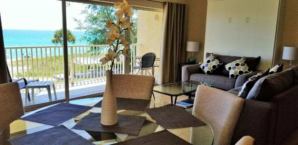 a living room with a vase with flowers on a table at Beach and sunset view from your balcony in Longboat Key