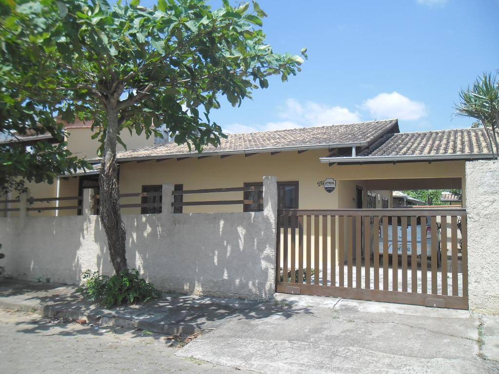 una casa con una valla y un árbol en casa Barra Velha - SC en Barra Velha