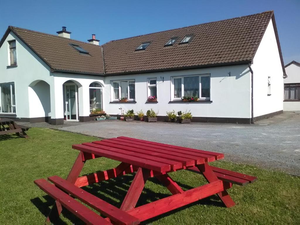 a red picnic table in front of a house at Cannville B&B in Lisdoonvarna