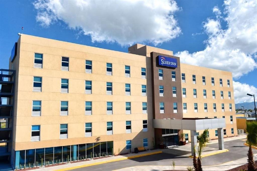 Sleep Inn Monclova في مونكلوفا: مبنى كبير اسمر عليه علامة