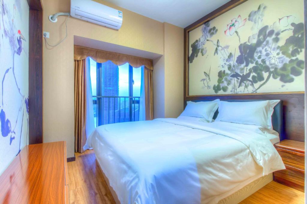 a bedroom with a large white bed and a window at Xing Yu Legend Service Apartment Canton Fair Branch in Guangzhou