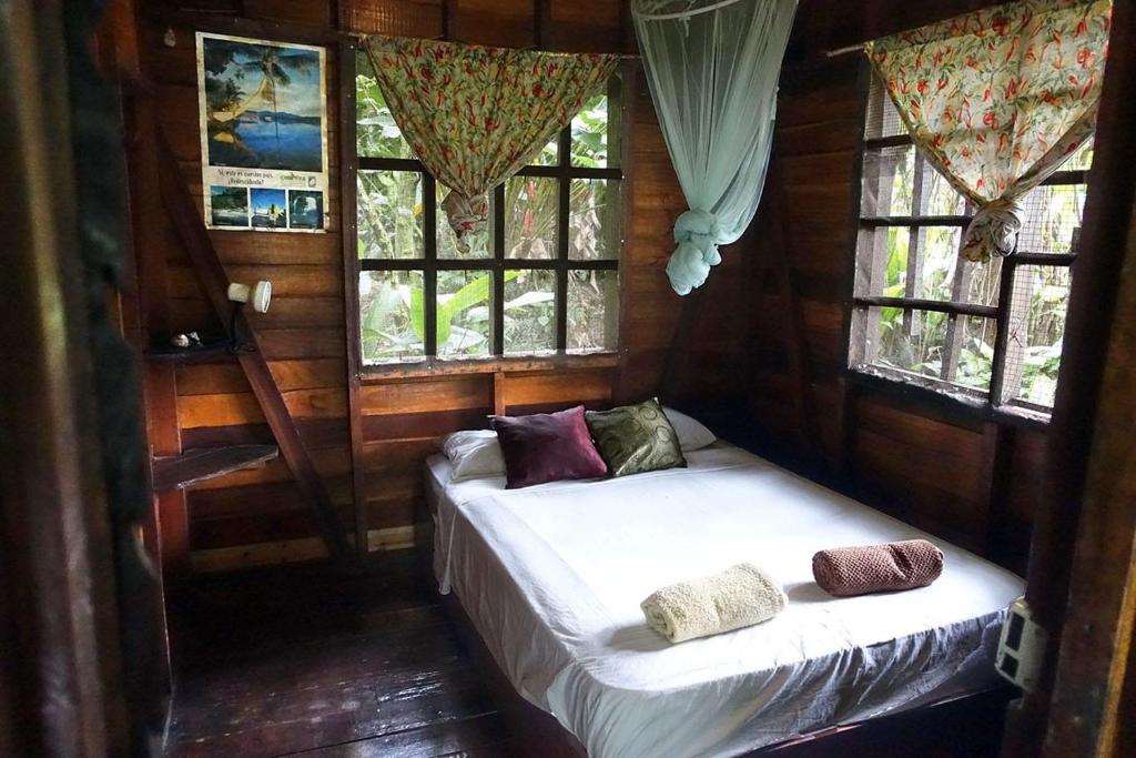 a bedroom with two beds in a room with windows at Beverly's Hill Guest House in Bocas Town