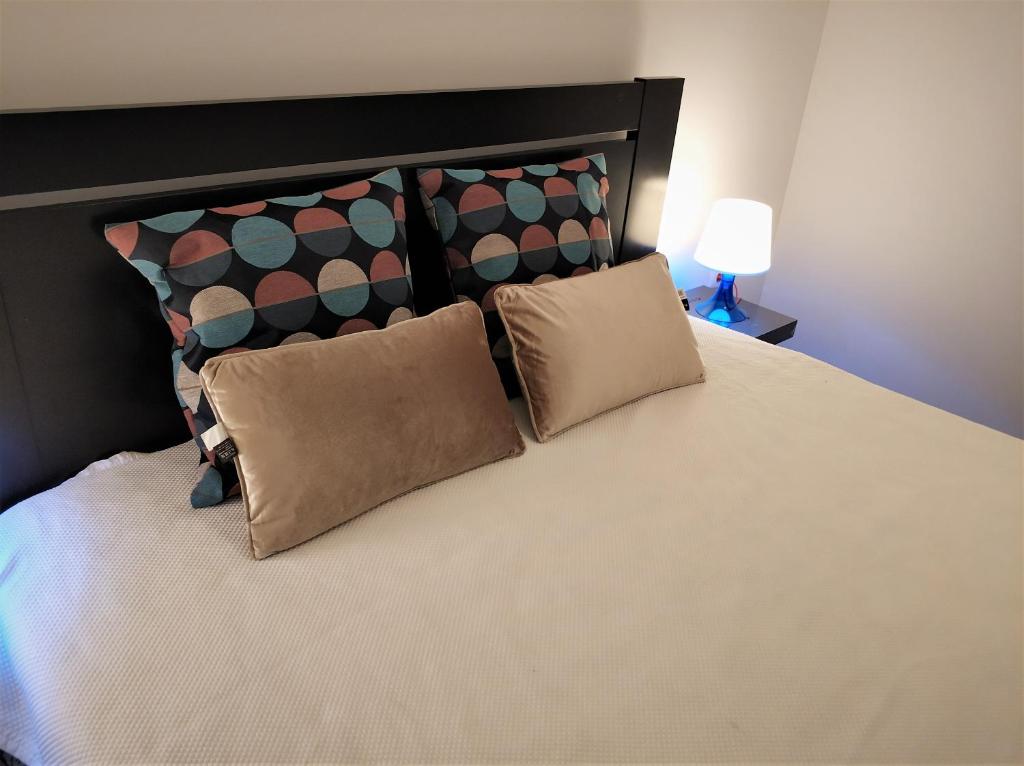 - une chambre avec un grand lit et 2 oreillers dans l'établissement Sleep & Go Faro Airport Guest House, à Faro