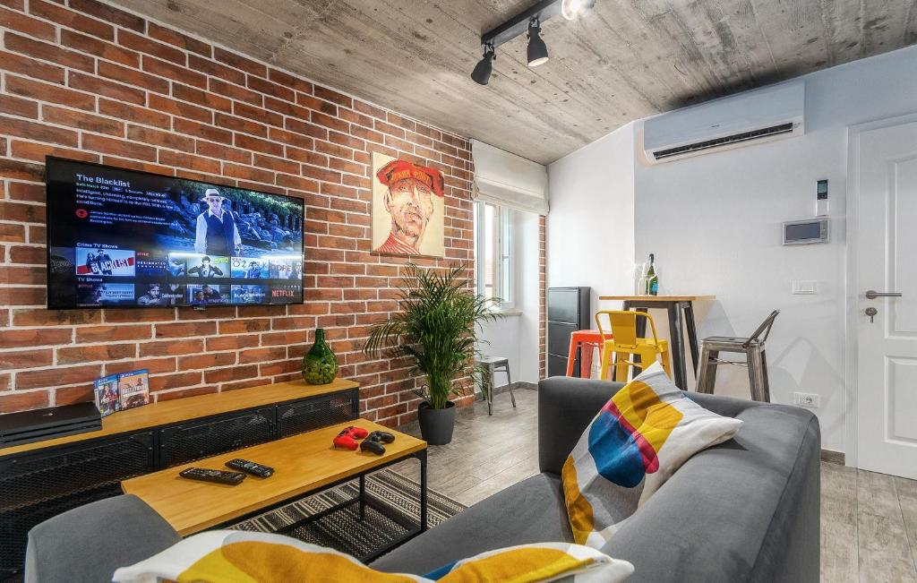 a living room with a brick wall and a tv at Orion apartment in Poreč