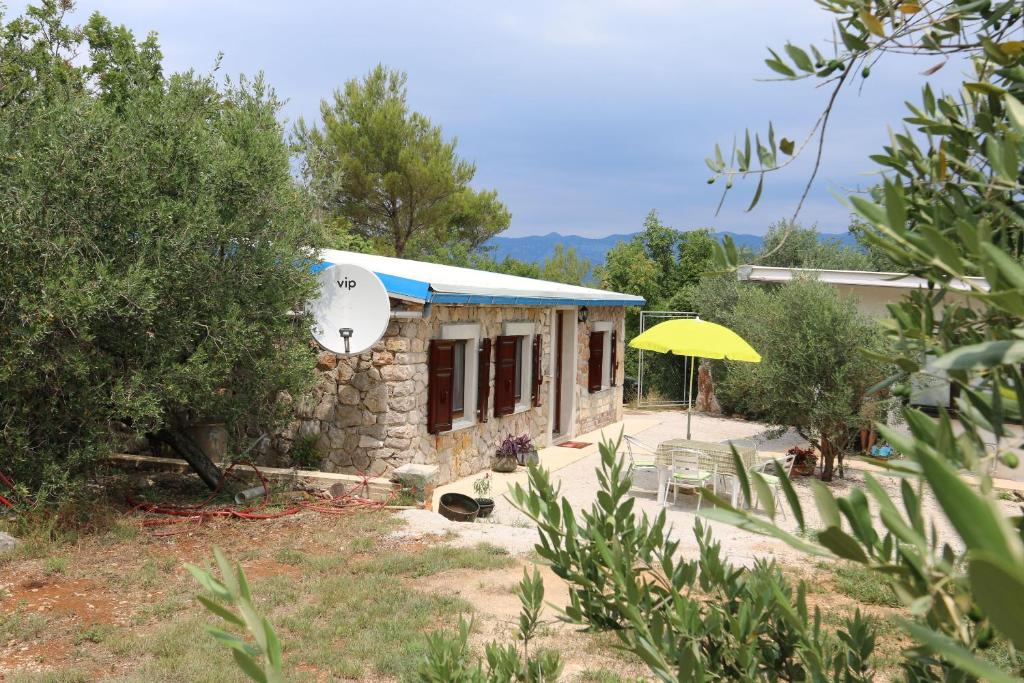 a small house with a yellow umbrella in a yard at House Car Mirko in Šilo